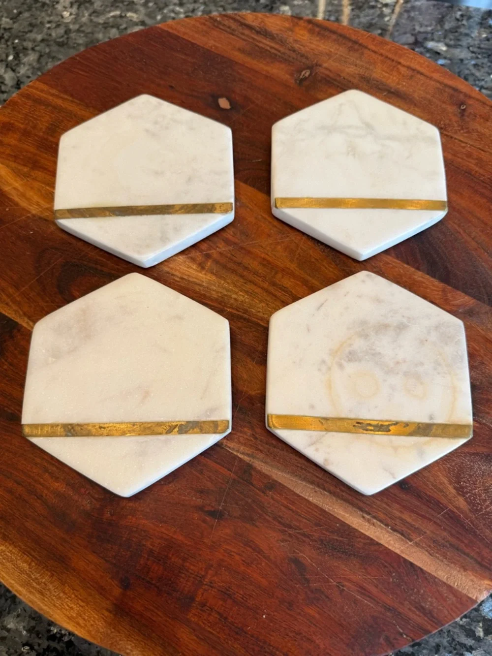 Hexagonal white marble coasters featuring a brass inlay design